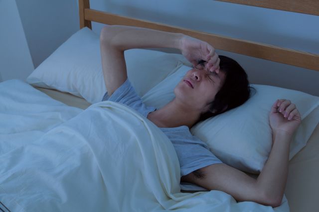 ベットで眠れない男性
